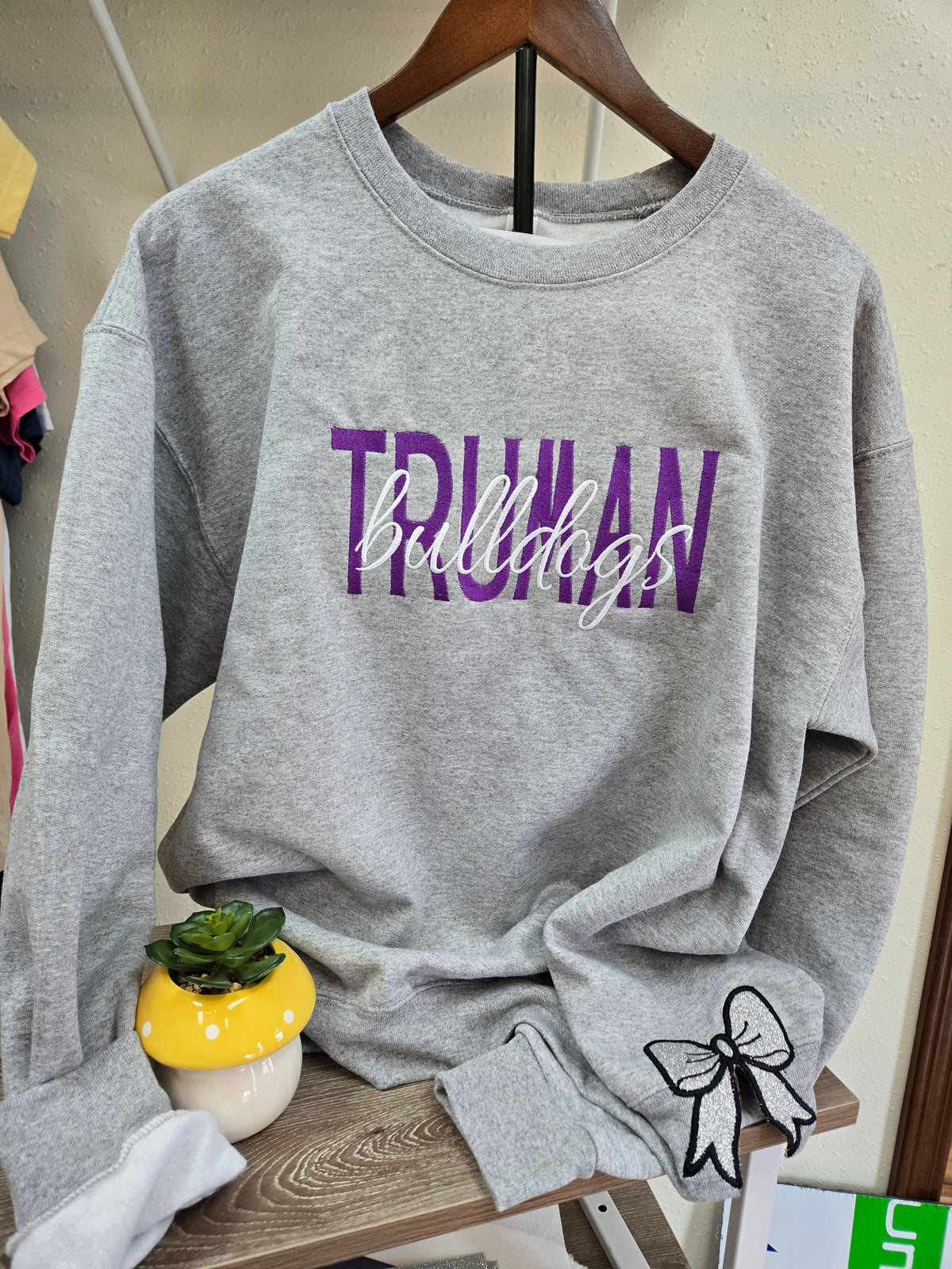 Truman Bulldogs Heather Gray Crewneck Sweatshirt | Purple Script + Glitter Bow Sleeve